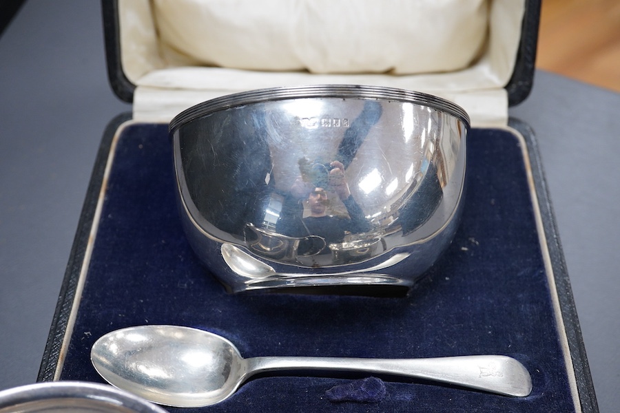 A George V Britannia standard silver mug, by Thomas Bradbury & Sons, Sheffield 1918, height 65mm, handle a.f., together with a 1930's silver porringer and a George V cased silver christening bowl and spoon, 13.2OZ.